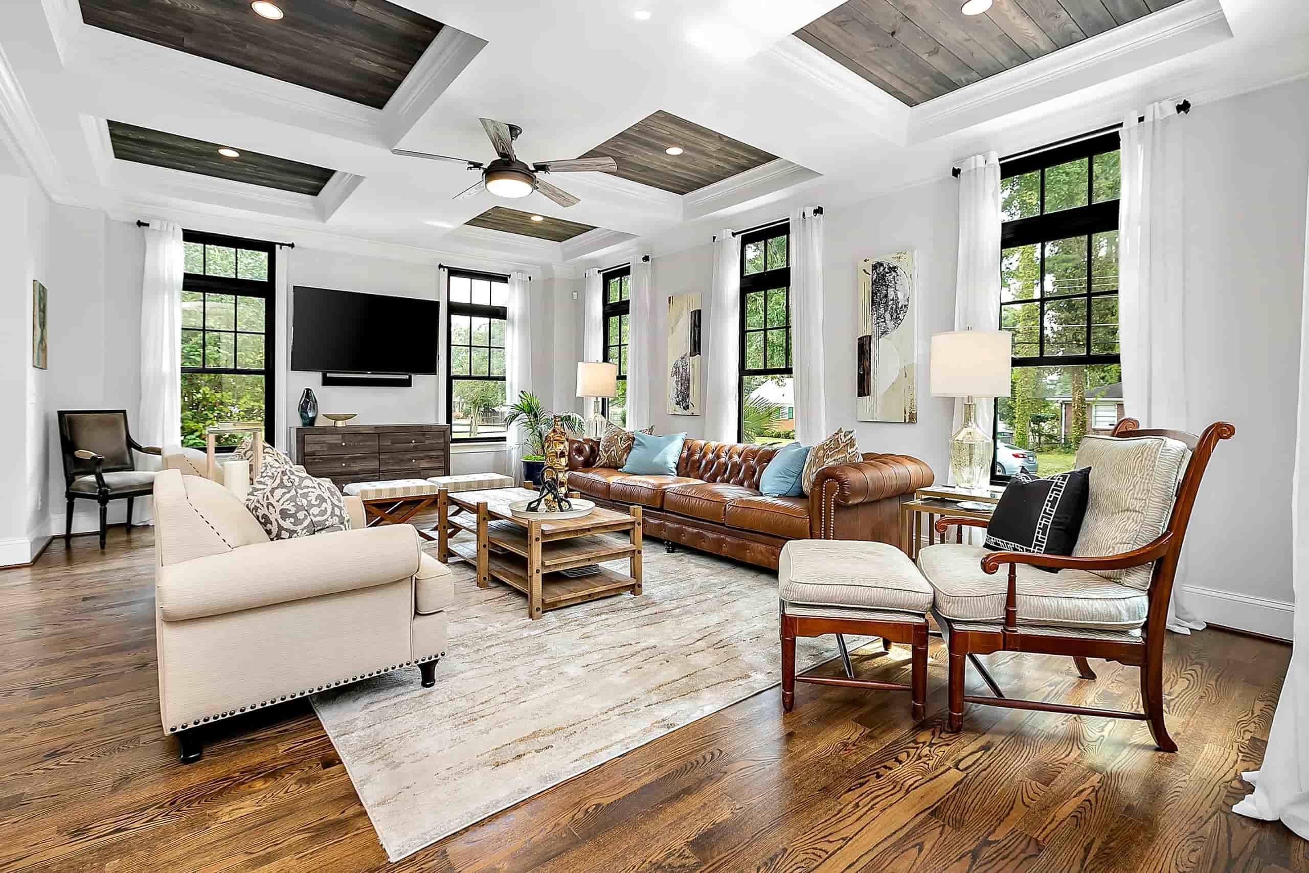 Completed M22 Construction living room with coffered ceiling, hardwood floors, and natural light