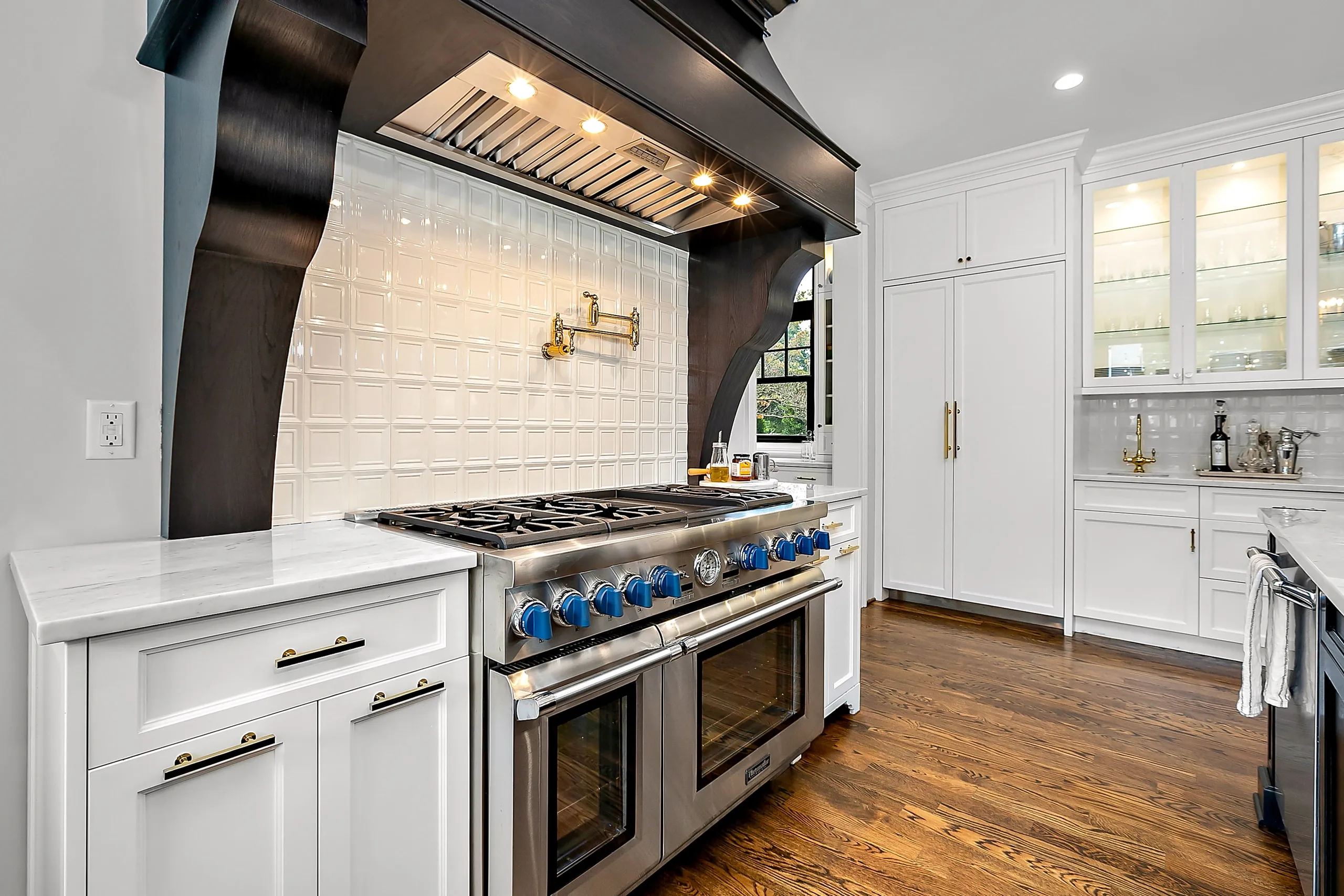 M22 Construction finished kitchen remodel — custom range hood, marble counters, white cabinetry